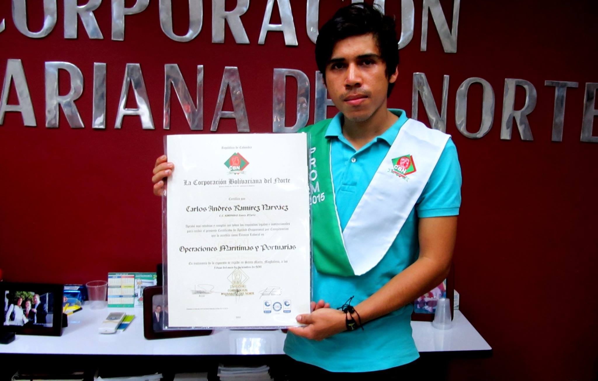 Un jeune homme tient un diplôme face à la caméra